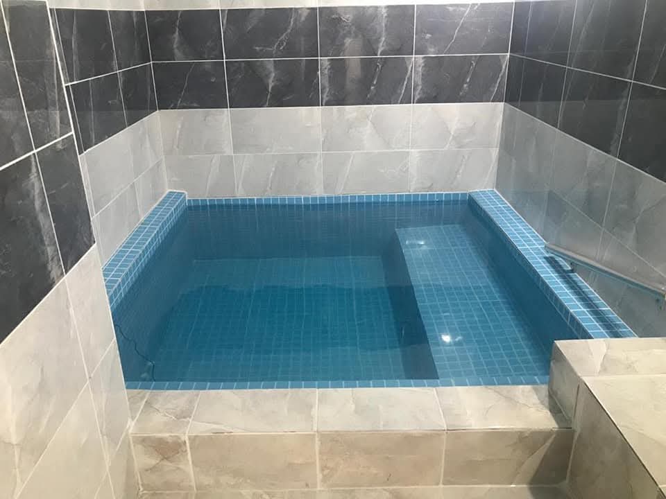 Konaklama biriminin içindeki termal havuz, gri mermer kaplama